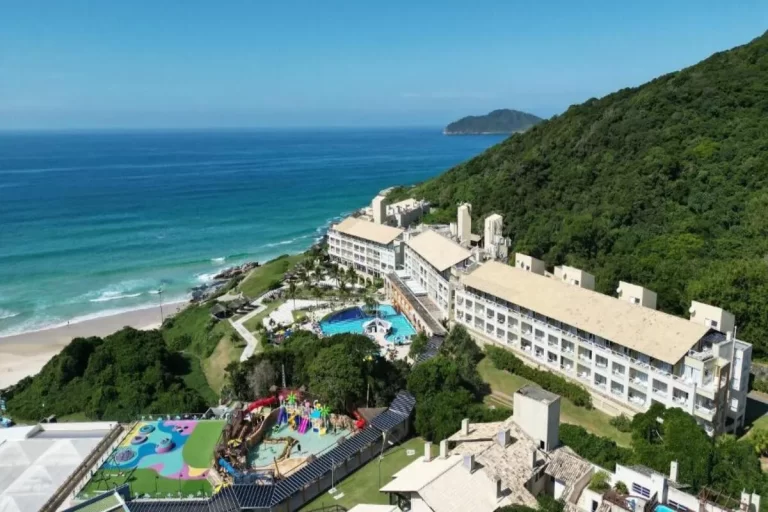 Vista aérea do resort Costão do Santinho à beira-mar em Florianópolis com parque aquático e natureza exuberante.