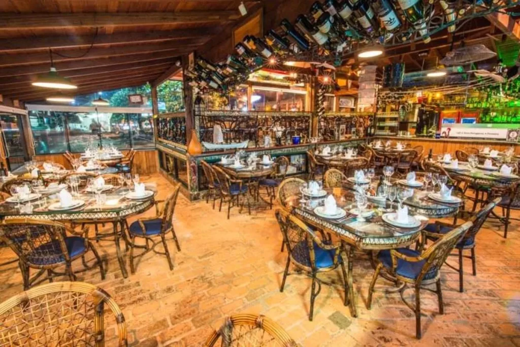 Mesas e decoração interna do restaurante Ostradamus em Florianópolis com estilo rústico