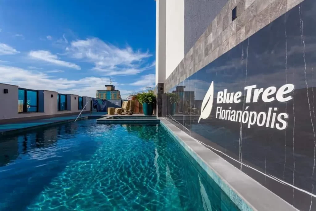 Piscina em hotel Blue Tree Florianópolis na cobertura, com céu azul e vista, ideal para lazer.
