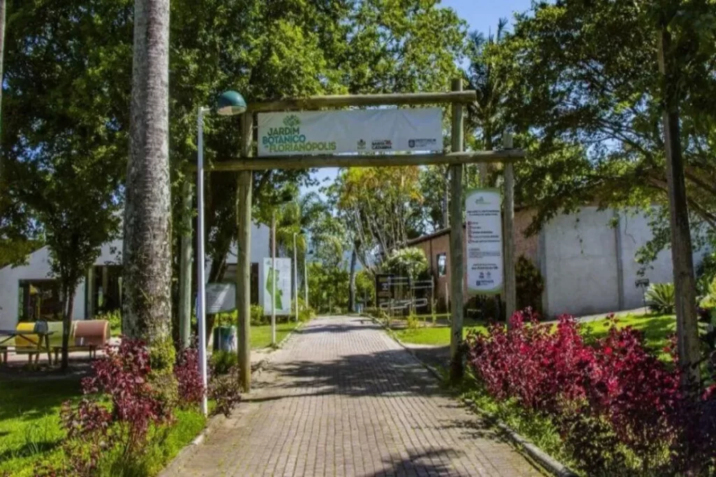 Entrada principal do Jardim Botânico de Florianópolis com um portal de madeira, caminho pavimentado e vegetação exuberante.