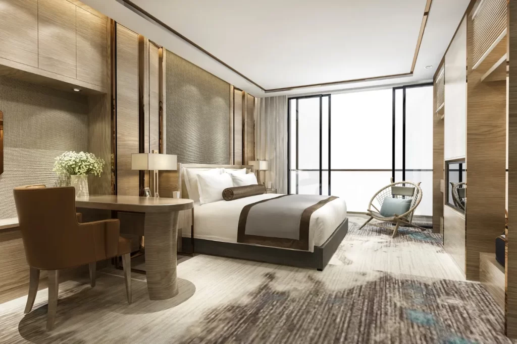 hotel boutique, quarto de luxo com cama de casal, poltrona de vime, e janelas do chão ao teto.