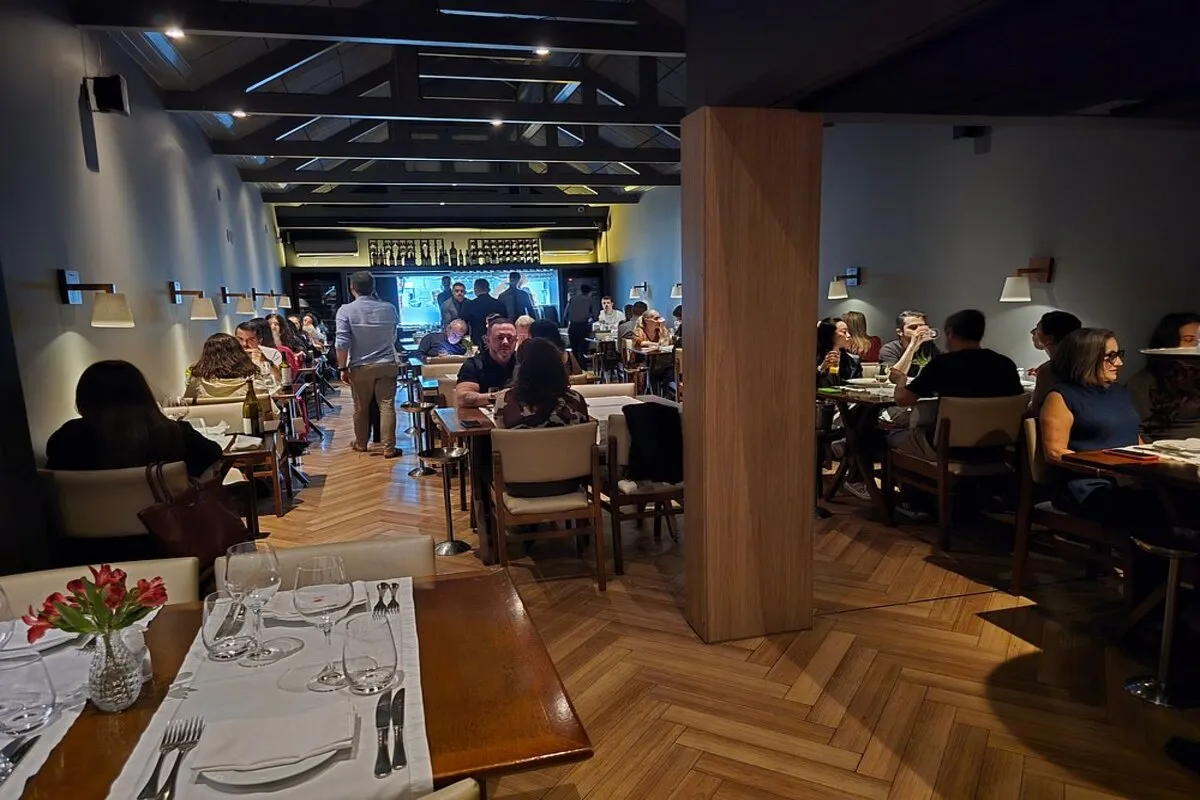 Clientes desfrutando de jantar no Artusi Restaurante em Florianópolis, em um ambiente sofisticado e acolhedor.