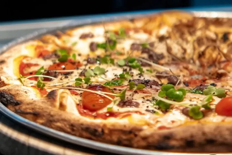 Pizza artesanal com tomates cereja, ervas frescas e massa de fermentação natural na Bere Birra Forneria.