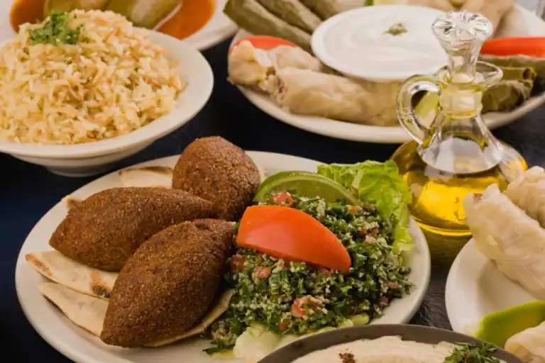 prato com quibe frito, tabule, pão sírio e acompanhamentos típicos da culinária árabe