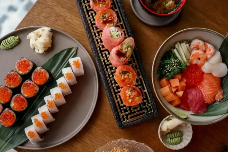 Pratos com sushi, sashimi e acompanhamentos japoneses organizados sobre mesa