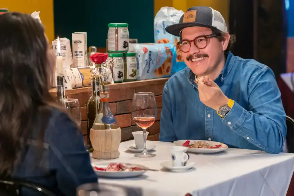 casal jantando em restaurante com vinho à mesa e clima intimista