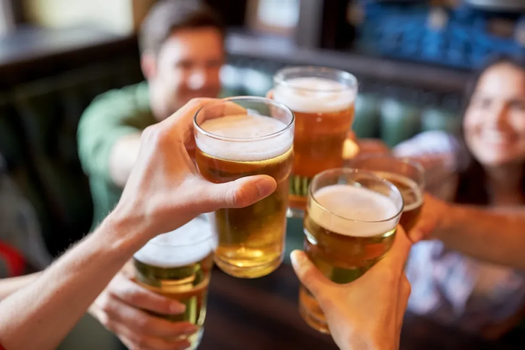 Bares em Jurerê Internacional. Pessoas brindando com copos de cerveja em um ambiente de bar descontraído