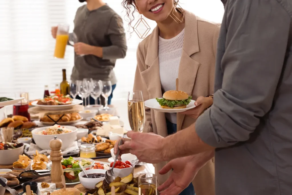 pessoas servindo comida em um buffet de brunch em Florianópolis com bebidas e pratos variados