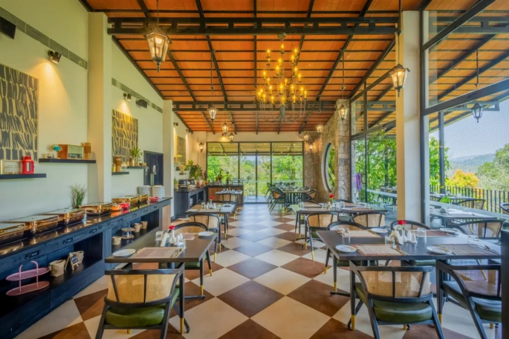 salão de restaurante amplo com mesas dispostas e janelas com vista para área externa