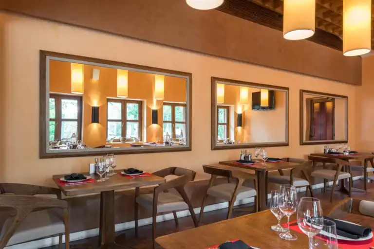 interior de restaurante com mesas organizadas, cadeiras de madeira e iluminação aconchegante
