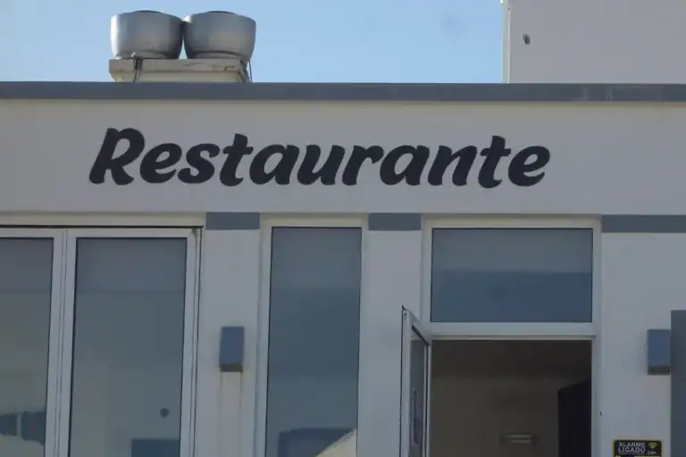 fachada de restaurante com placa escrita restaurante e entrada com portas de vidro