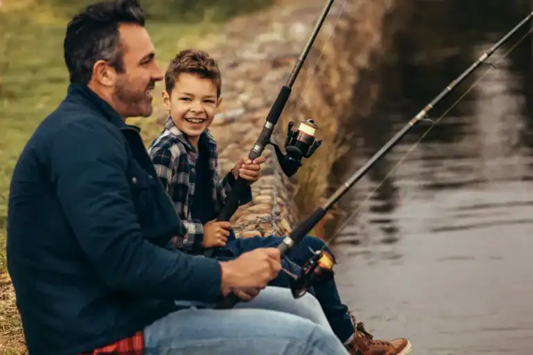 homem e criança pescando juntos com varas de pesca à beira de um rio