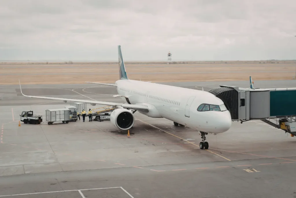 avião conectado ao finger em aeroporto com equipe de solo ao redor, representando logística de embarque para Florianópolis