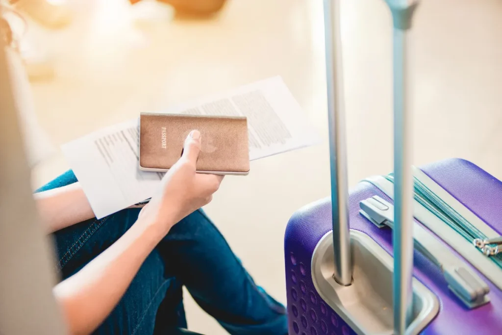 passageiro segurando documentos e mala de viagem ao lado, representando preparacao para embarque no aeroporto de Florianopolis