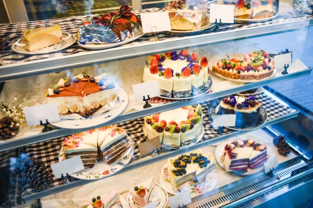 Confeitarias Florianópolis. Vitrine de confeitaria com bolos decorados com frutas e coberturas variadas