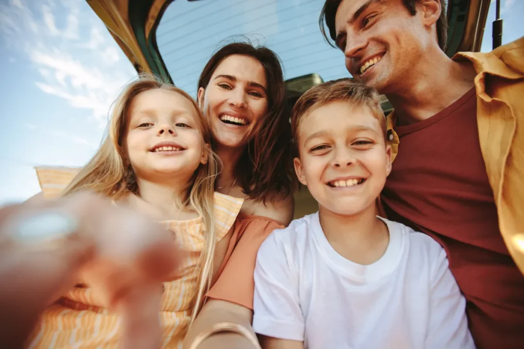 familia sorrindo dentro do carro durante viagem, representando deslocamento de Florianopolis para Porto Alegre com conforto