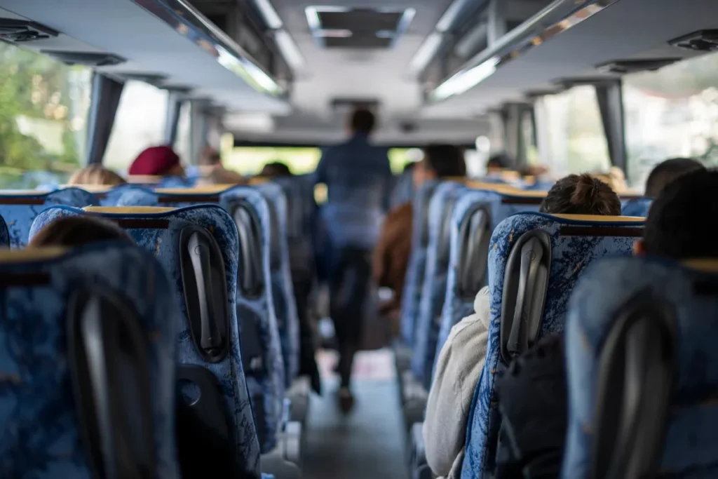 Interior de ônibus com passageiros sentados durante viagem, mostrando opção de transporte entre Florianópolis, Criciúma e Lages