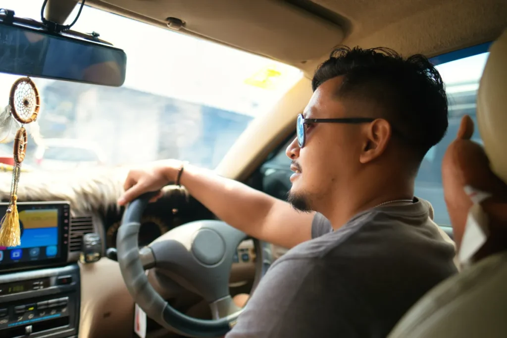 motorista dirigindo carro com foco no volante e painel interno, representando trajeto rodoviario entre Florianopolis e Porto Alegre