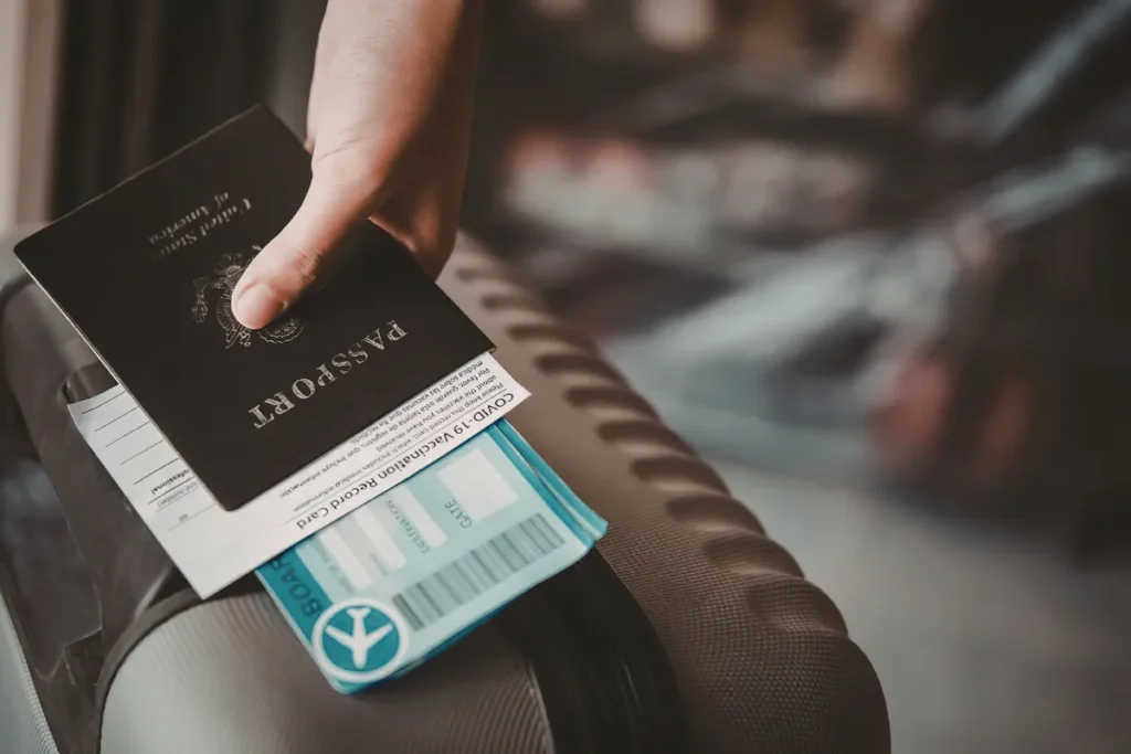 mao segurando passaporte e cartao de embarque sobre mala, representando check in no aeroporto de Florianopolis