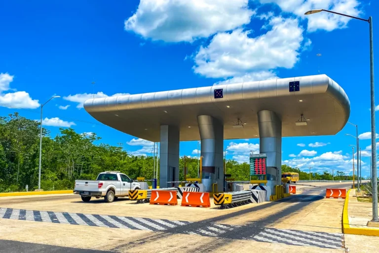 Praça de pedágio em rodovia com cabines de cobrança e veículos passando, representando pedágios na BR-101 em Santa Catarina