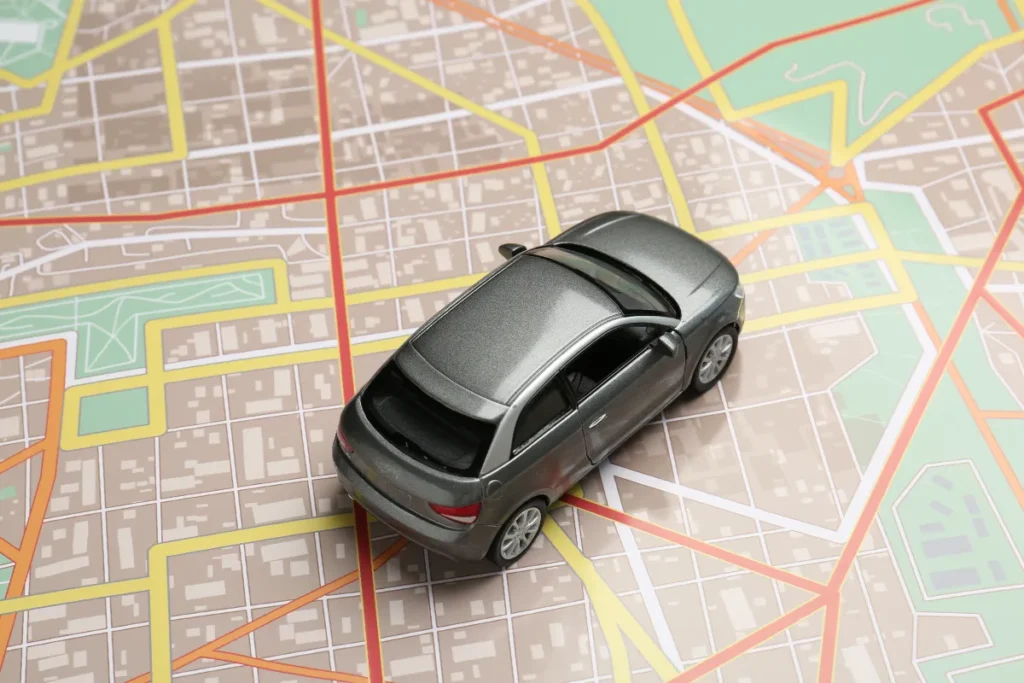 Miniatura de carro sobre mapa com ruas destacadas, representando planejamento de rota entre Florianópolis, Criciúma e Lages