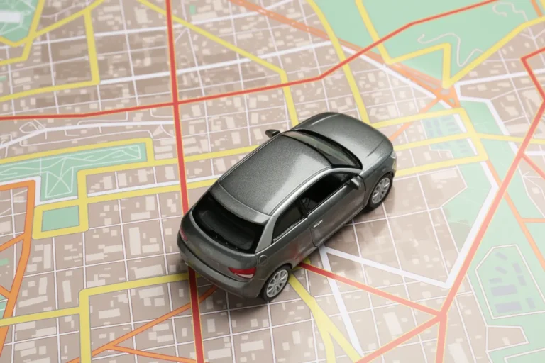 Miniatura de carro sobre mapa com ruas destacadas, representando planejamento de rota entre Florianópolis, Criciúma e Lages