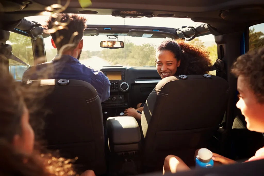 Família dentro de carro em viagem, representando alternativa ao transporte público em Florianópolis para turistas explorarem a ilha