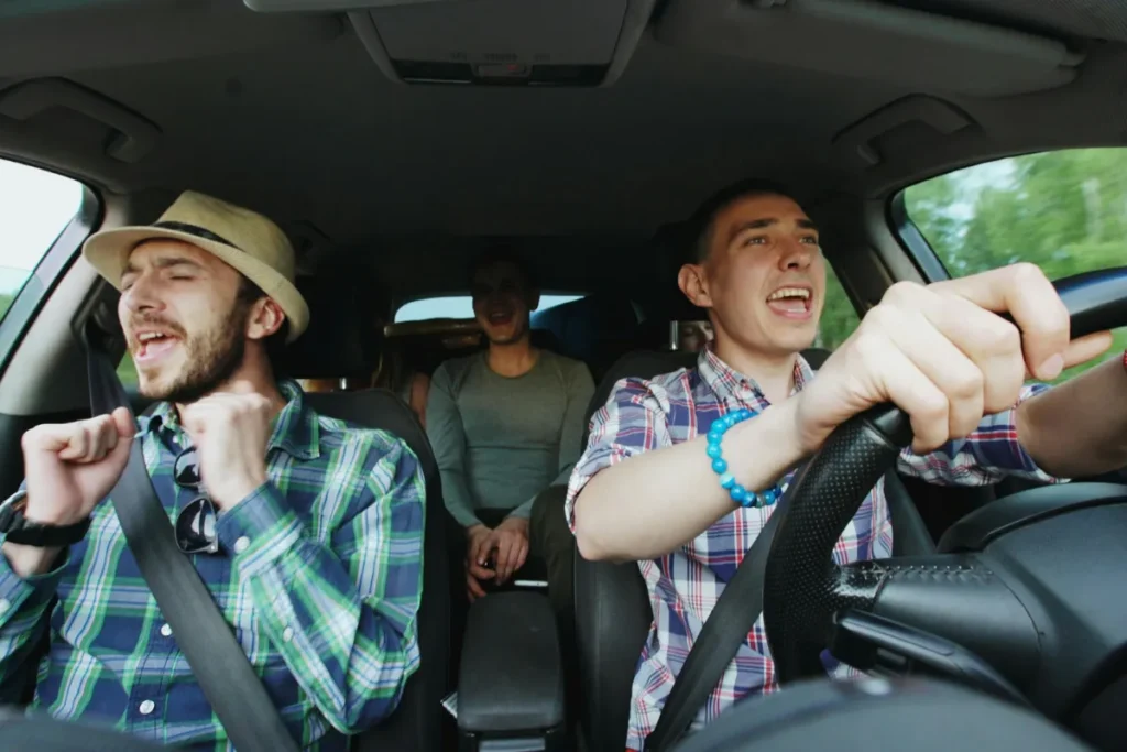 grupo de amigos animados dentro de carro durante viagem pela estrada, representando trajeto de Florianópolis para Curitiba