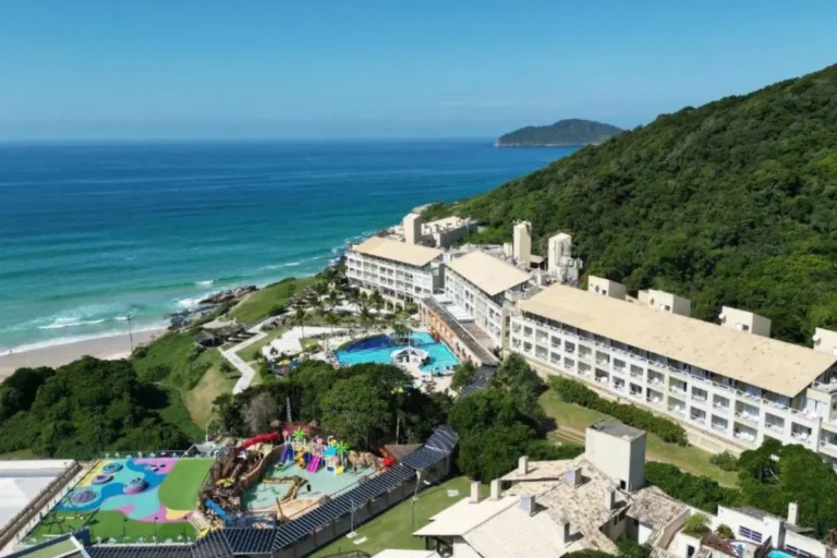 Vista aérea do Costão do Santinho com praia, piscinas e estrutura do resort em Florianópolis.