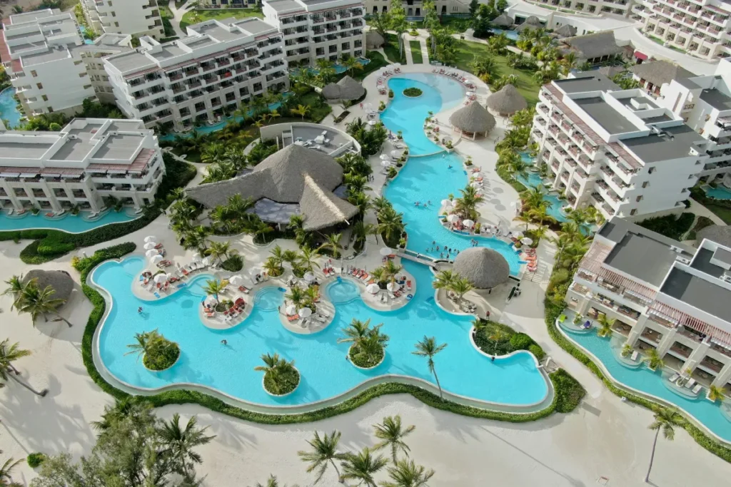 Vista aérea de resort com piscinas interligadas, áreas de lazer e estrutura completa para famílias.