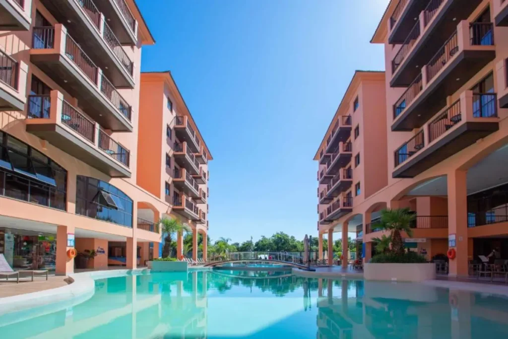 Piscina do Jurerê Beach Village cercada por prédios residenciais e área de convivência em Florianópolis.