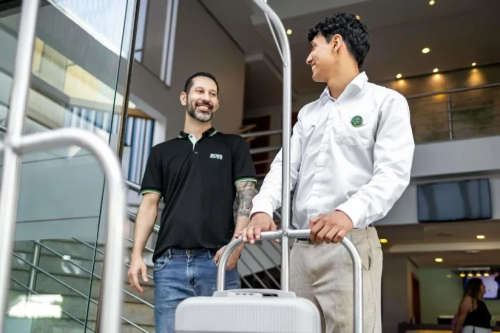 Hóspede chegando ao Hotel Mercure Florianópolis com mala e atendimento cordial na entrada do hotel