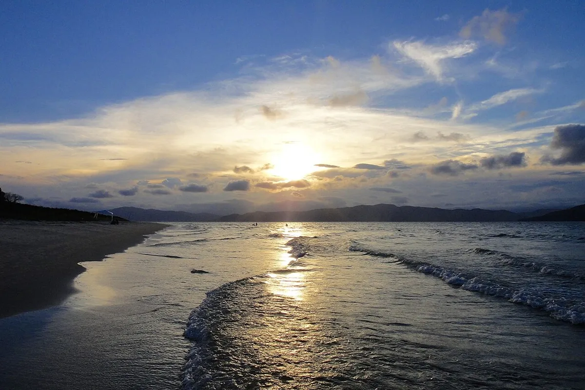 Pôr do sol refletido no mar da Praia da Daniela em Florianópolis