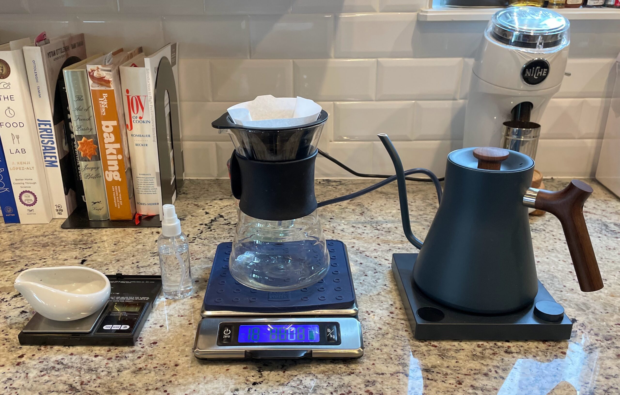 Equipamentos para preparo pour-over com filtro, jarra, balanças, chaleira de bico fino e moedor.