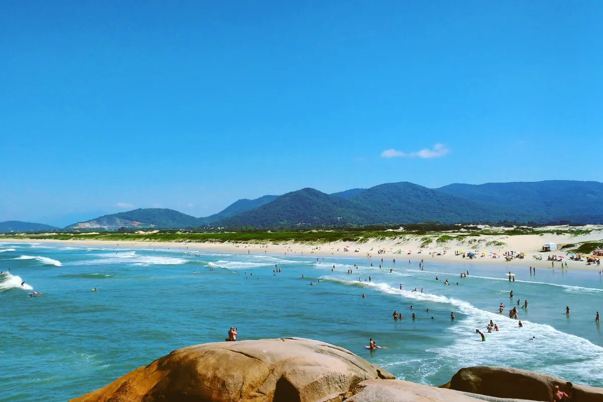 Praia da Joaquina com mar e faixa de areia em Florianópolis