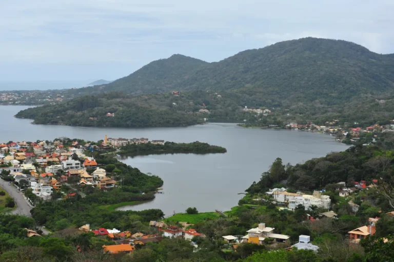 Vista panorâmica da Lagoa da Conceição, com casas, morros e vegetação em Florianópolis.
