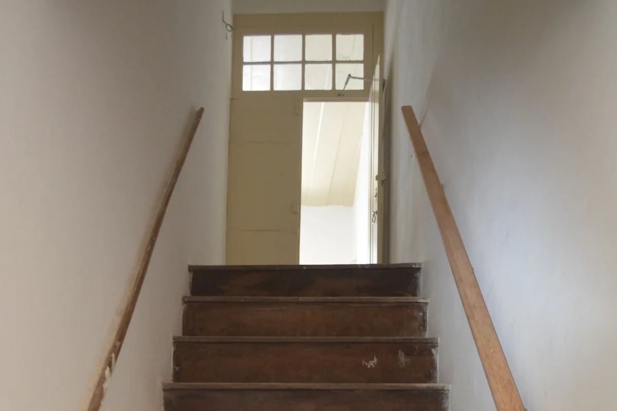 Escada interna de madeira da Casa Histórica do Museu Victor Meirelles, com corrimãos nas duas laterais.