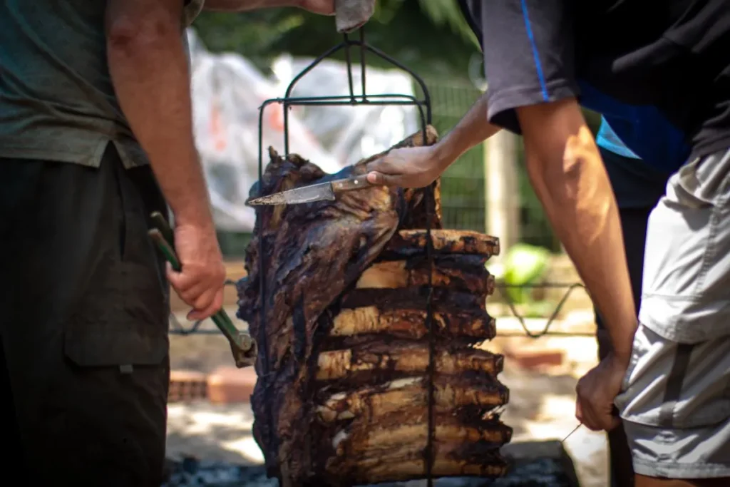 Costelas assadas sobre o fogo durante preparo de churrasco
