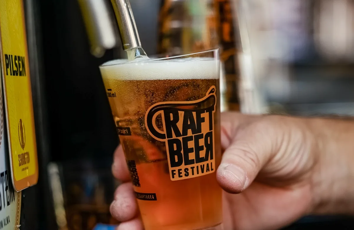 Copo do Craft Beer Festival sendo servido com chope na torneira